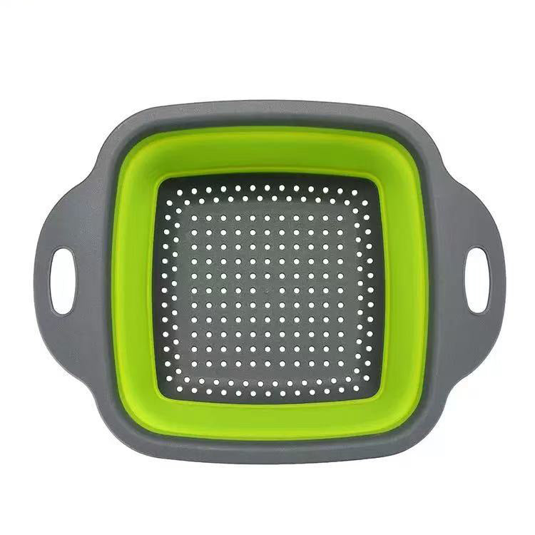 Foldable silicone vegetable storage basket in square shape with green interior and grey exterior.
